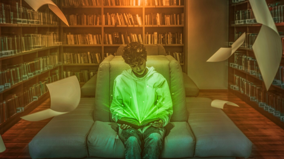 Joven leyendo un libro en una biblioteca mientras páginas flotan a su alrededor, simbolizando el poder transformador y mágico de la lectura