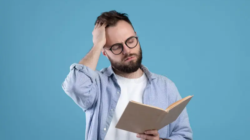 Joven con dificultad para leer frente a un libro