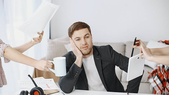 Persona con sobrecarga de trabajo que refleja fatiga mental y dificultad para concentrarse.