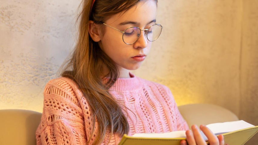 Adolescente leyendo un libro con concentración, representando el desafío de fomentar el hábito lector